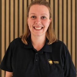 Smiling woman wearing a black polo shirt with the Tembo Safari logo.