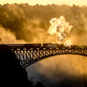 Damptog der kører over brugen ved Victoria Falls